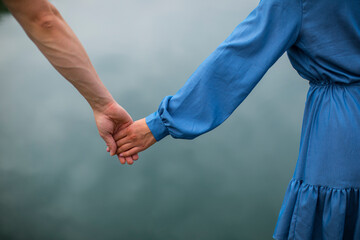 Couple hands closed together outdoors in love and romantic relationship. 