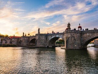 Obraz premium Image of an Old Main Bridge on the river under the cloudy sunset sky.
