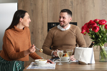 Happy engaged couple having dinner in kitchen