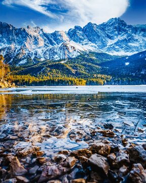 Fototapeta Vertical shot of the Eibsee lake with snowy mountains in the background