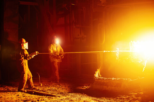 Metallurgists taking samples of liquid molten metal