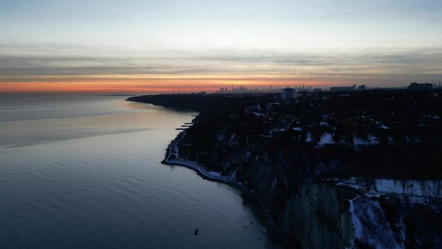 Aerial shot of a coastal city on a hgh cliff at dusk