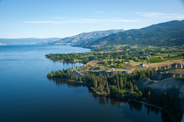 Landscape view of Okanagan Lake with vineyards ad orchards near the beach