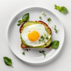 View from the top of avocado toast with spinach nd fried egg on a white plate 