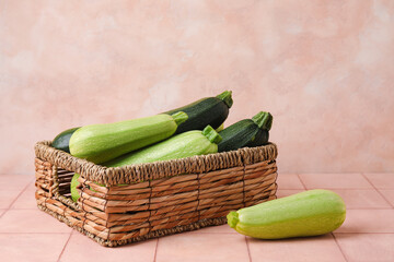 Wicker basket with raw zucchini on table