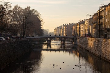 Latin bridge view at sunset with water reflecting houses around