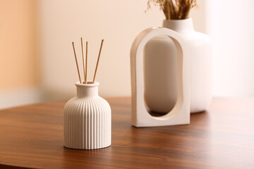 Bottle of reed diffuser and decor on table in room, closeup