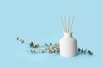 Reed diffuser and eucalyptus branches on blue background