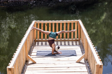 young and handsome dark-skinned mexican latino man with bohemian style practicing yoga on dock