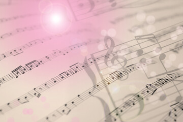 Double exposure of sheets with music notes as background, closeup. Bokeh effect