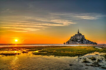 Scenic view of the Mont Saint-Michel island with a beautiful sunset visible in the background