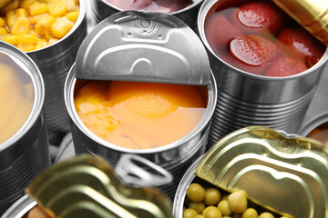 Open tin cans with different products, closeup