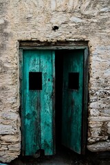 Vertical shot of an ancient wooden door on a stone wall