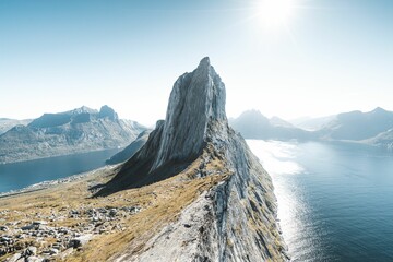 Drone shot of a huge rocky hill on the coast under the sunny sky