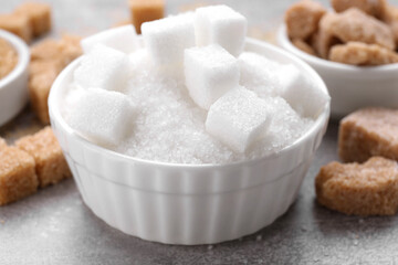 Different types of sugar on grey table, closeup