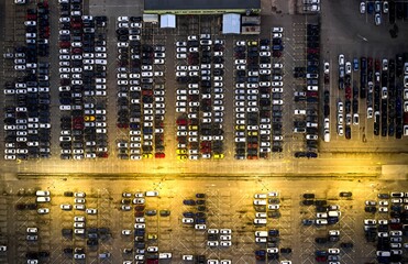 Aerial view over a parking lot with cars at night time