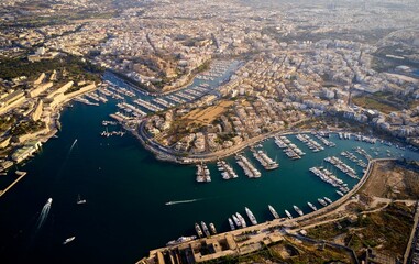 Drone view over a sea and harbor surrounded by cityscape of Valetta in Malta