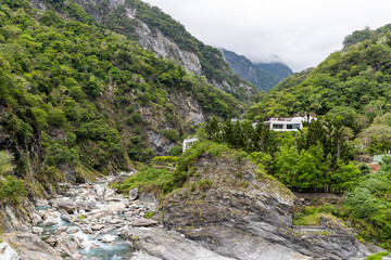 Fototapeta na wymiar narrow turquoise liwu river gorge underneath and high mountain cliff face in taroko national park