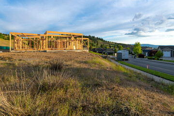Fototapeta na wymiar A luxury home framed and under construction at a hillside subdivision of homes in a suburb of Spokane, Washington, USA.