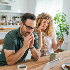 adult couple man and woman shopping online use laptop hold credit card