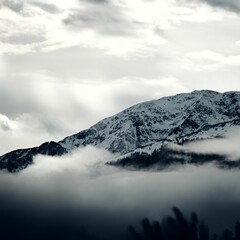Grayscale view of the snowy Steinbergstein Mountain on a foggy day in the Kitzbuhel Alps, Austria