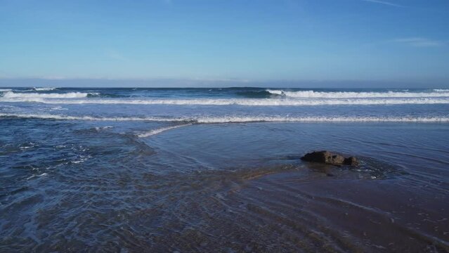 Aerial foamy waves of the sea of the Ferrol Beach in Galicia, Spain during the daytime