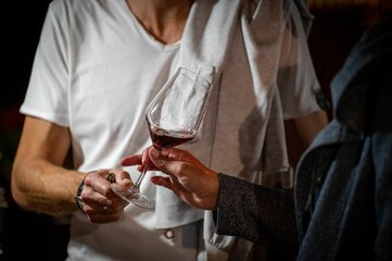 Closeup of human hands holding a glass of red wine