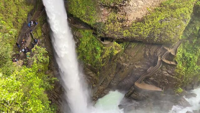 Big foamy Pailon del Diablo waterfall in Ecuador surrounded by green trees