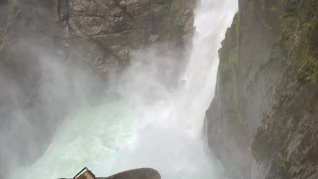 Big foamy Pailon del Diablo waterfall in Ecuador surrounded by green trees
