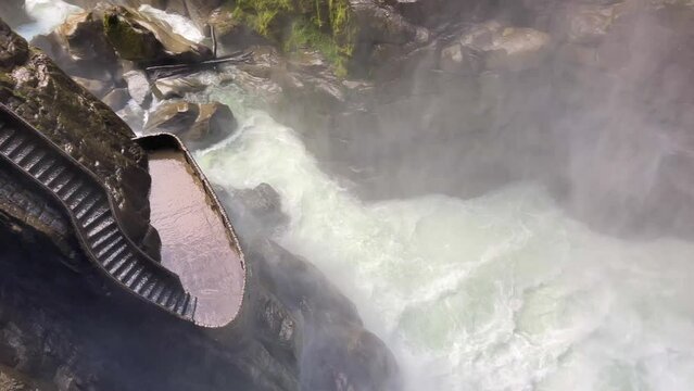 Big foamy Pailon del Diablo waterfall in Ecuador surrounded by green trees