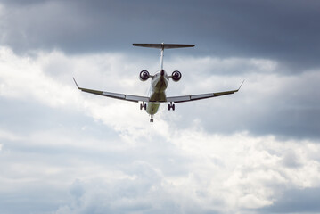 Takeoff of a jet passenger plane, rear view. Jet plane on the background of a cloudy sky