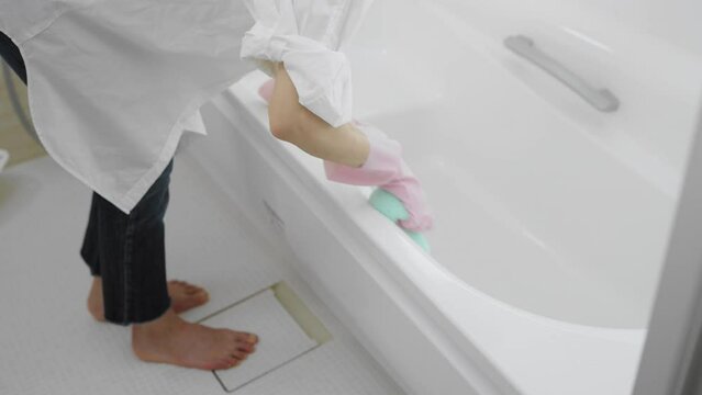 お風呂の浴槽を洗う若い女性　ライフスタイルイメージ