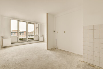 an empty room with white walls and tile on the floor, there is a large window in the corner that looks out to the