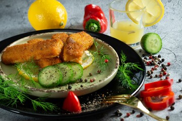 Closeup of chicken nuggets served with vegetables on a plate