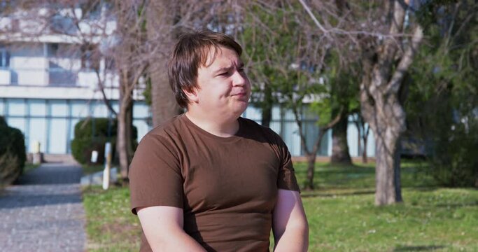 Man sits in park, toils from idleness, break looks at passers-by with curiosity, watches, sighs accusingly, shakes his head Generation conflict, misunderstanding. Gossip on bench. Bored lonely tourist