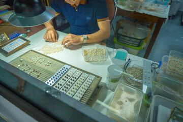Closeup and Selective Focus of Cultured Pearls inside Oyster Shell. pearl diver showing how to open...