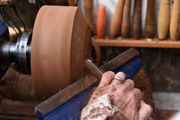 Closeup view of the process of making a wooden bowl on a woodturning machine