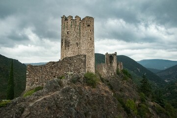 Ruins of the medieval Cathar Castles on top of the mountain in France against the cloudy sky