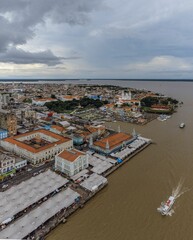 Fototapeta na wymiar Aerial shot of the coastal city with ships on the sea against a clouded sky