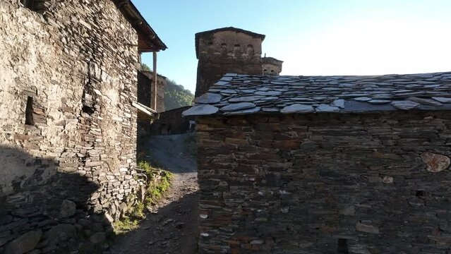 Aerial drone footage of the Ushguli village with Svan towers in Svaneti region in Georgia. Medieval stone tower houses with Caucasus Mountains at background. Flying over remote village in Georgia