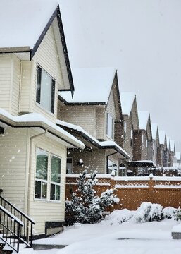 Vertical shot of a row of condo houses covered in snow in the winter