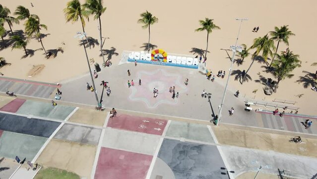Aerial of people walking and resting on the sandy beach in Joao Pessoa Brazil