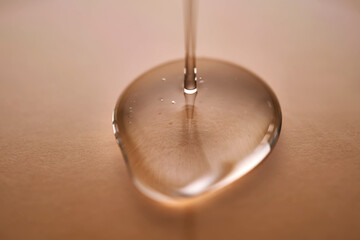 A juicy drop of gel on a beige background.