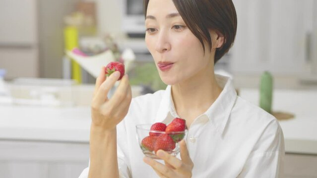 イチゴを食べる若い女性　飲食イメージ