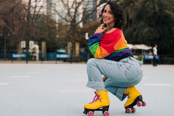 bella mujer latina sonriendo, con frenillos, maquillaje y en patines con polera de arcoíris lgbtq...