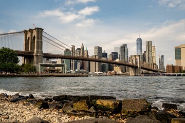 View of the Brooklyn Bridge and New York skyline from the bank of the East River, New York, USA