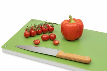 Vegetables on green professional chopping board on white background