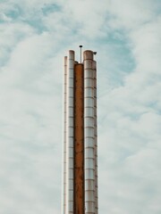 Two tall cement towers against a cloudy sky background on a sunny day
