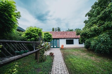 Trail with paving stones leading to a house,yard covered with grass