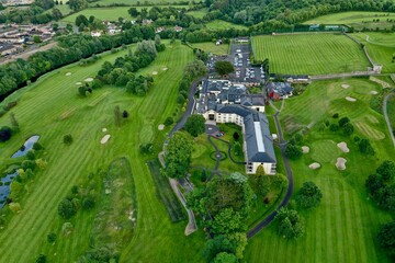 Fototapeta premium Aerial shot of lush green fields and houses